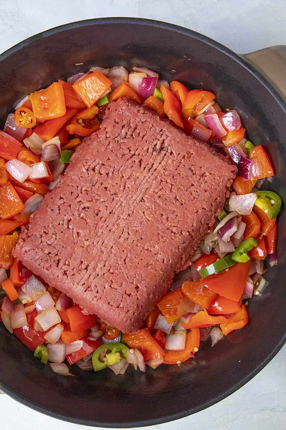 Add the plant-based protein starter to the pan with the peppers, onion and tomatoes