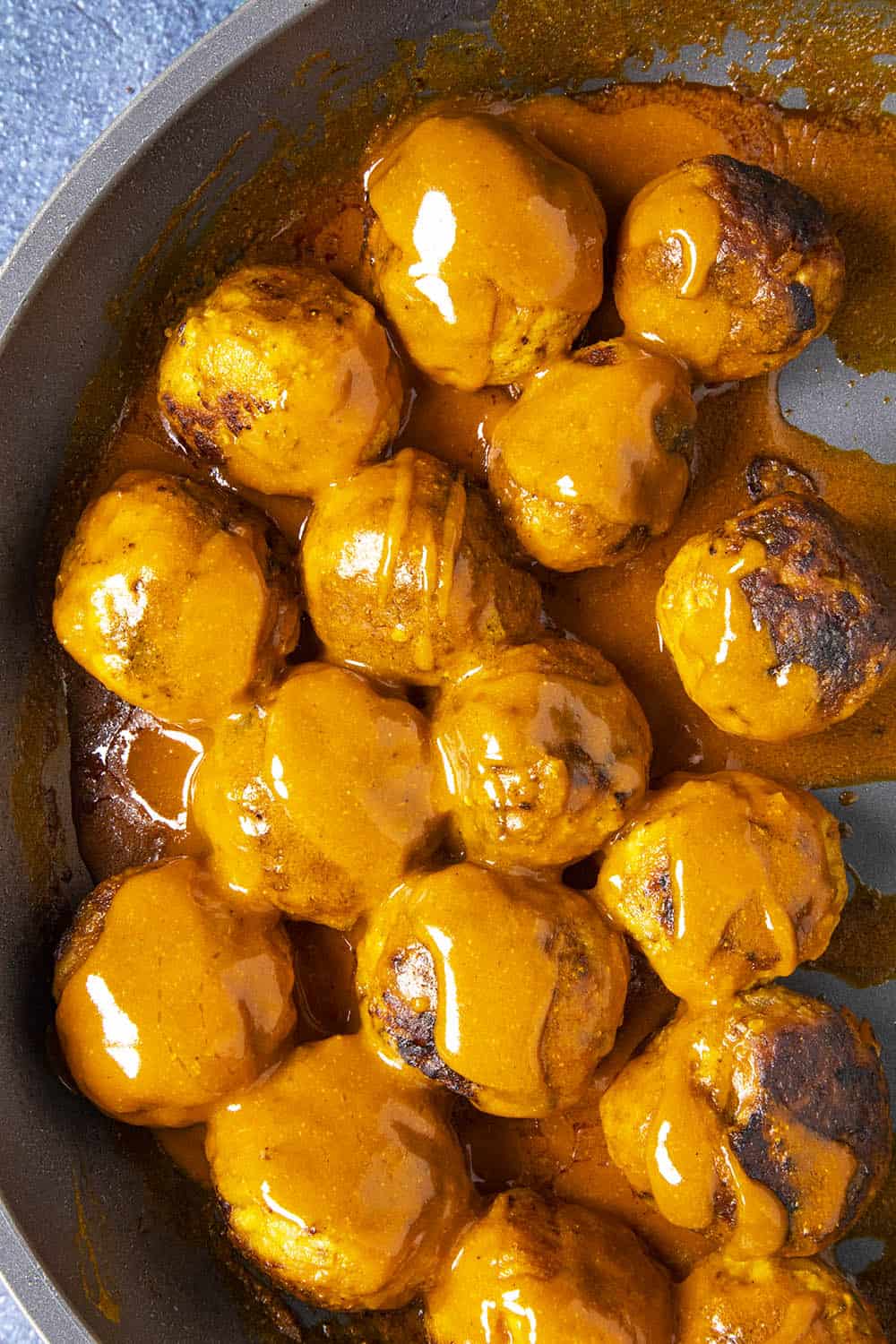 Buffalo Chicken Meatballs in a pan with extra Buffalo sauce