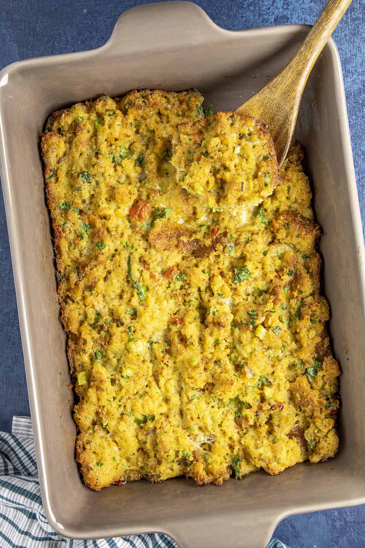 Cornbread Dressing being scooped from the casserole dish