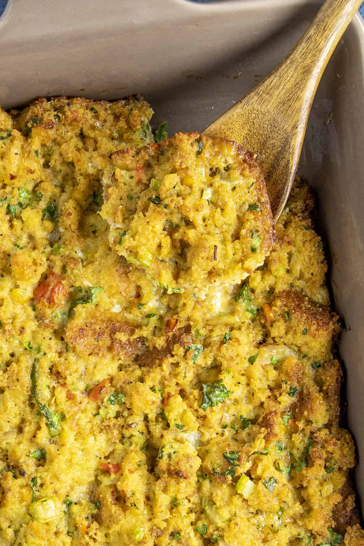 Cornbread Dressing being scooped from the casserole dish