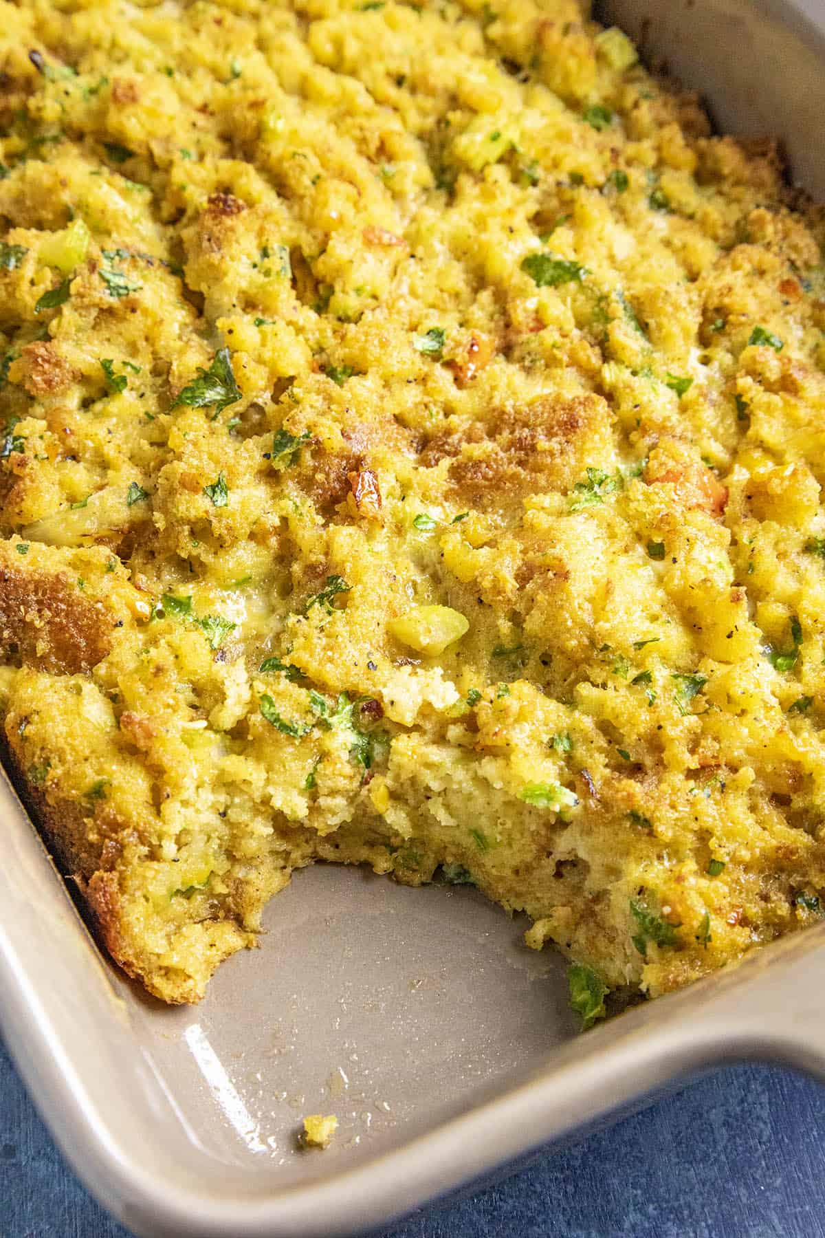 A scoop of Cornbread Dressing missing from the casserole dish