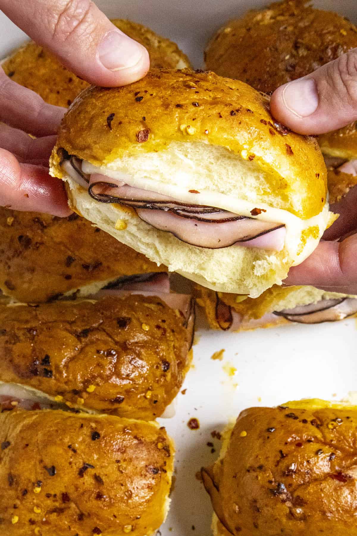 Holding one of the Spicy Crack Ham and Cheese Sliders.