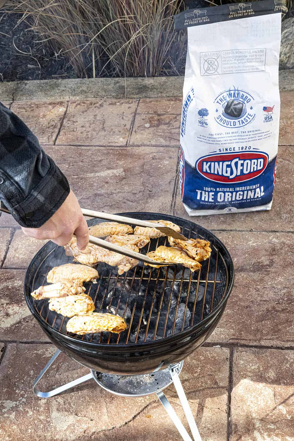 Flipping the grilled chicken wings on the grill