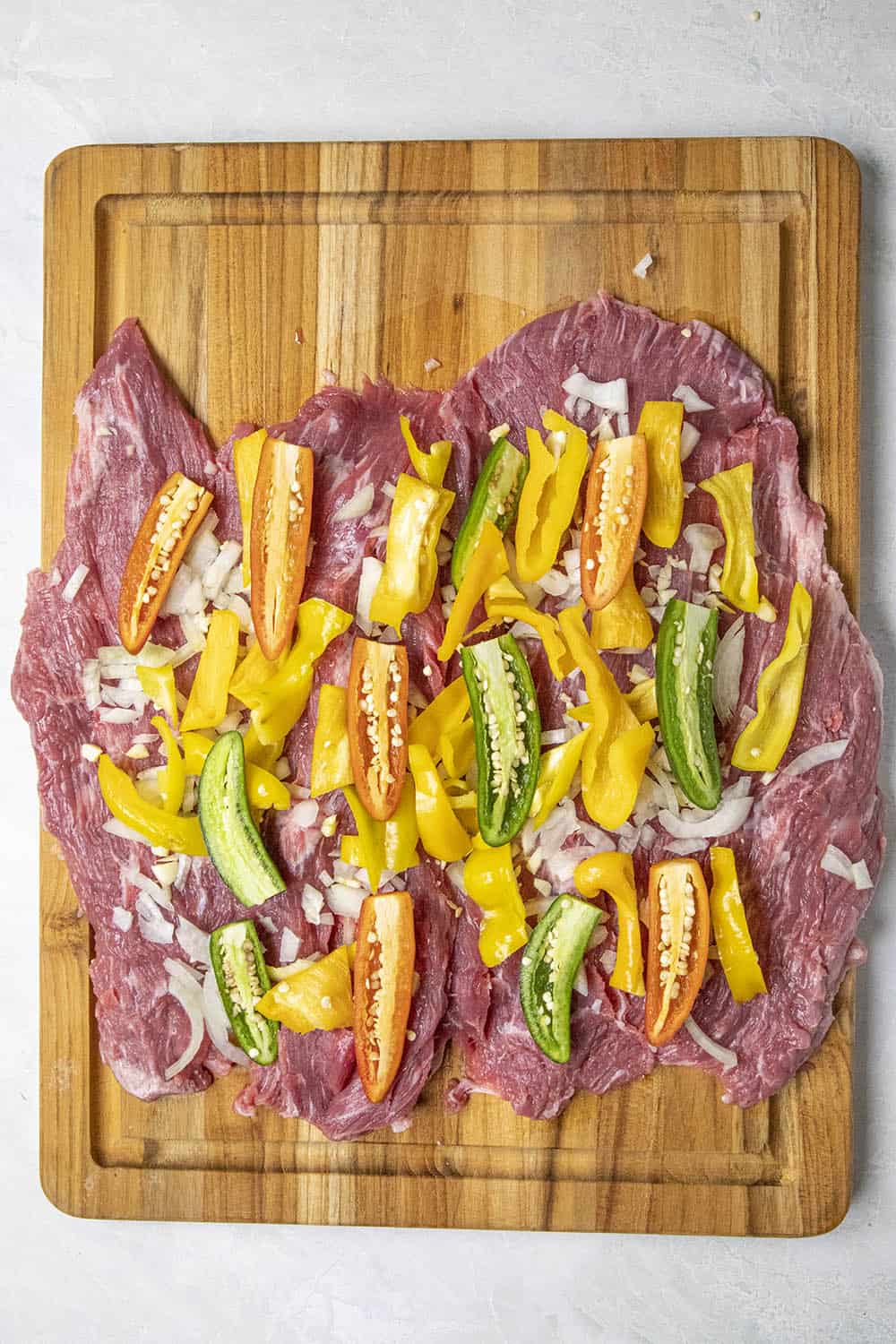 Adding peppers to the flank steak