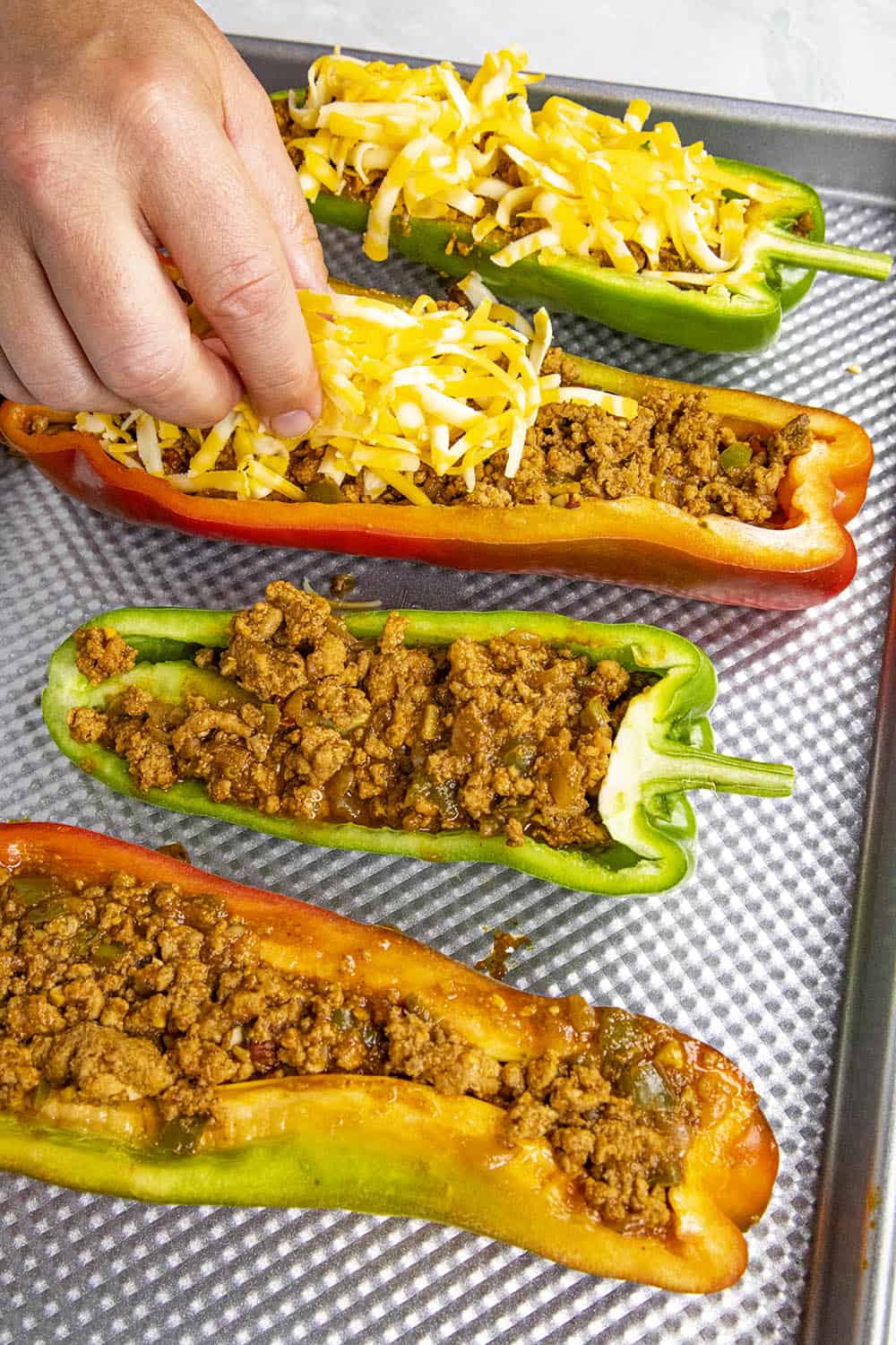 Topping the stuffed peppers with cheese