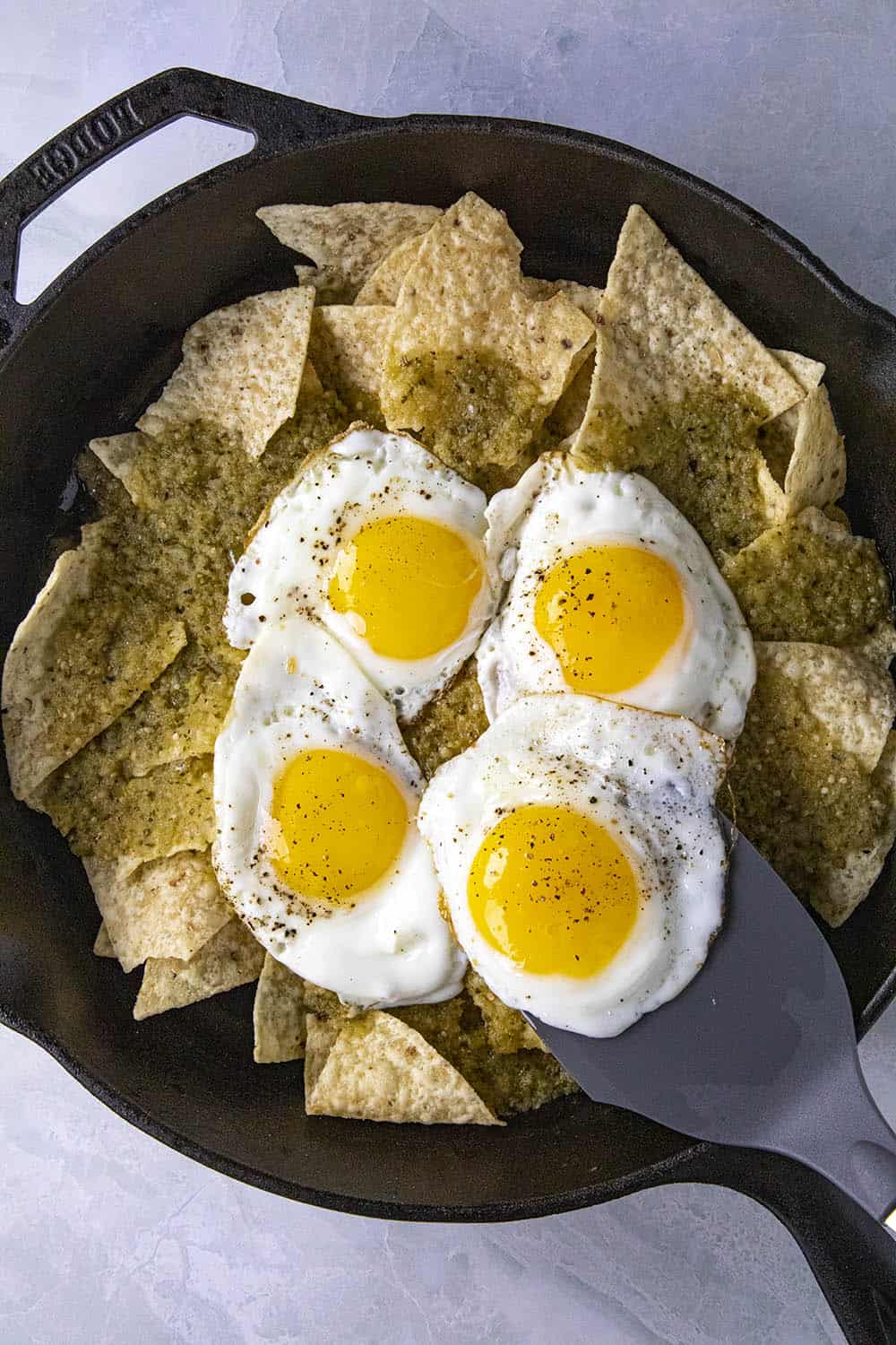 Topping the tortillas with fried eggs