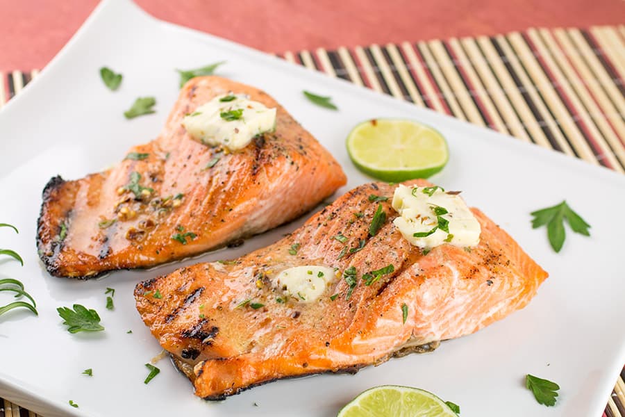 Grilled Steelhead Trout with melted butter on a plate