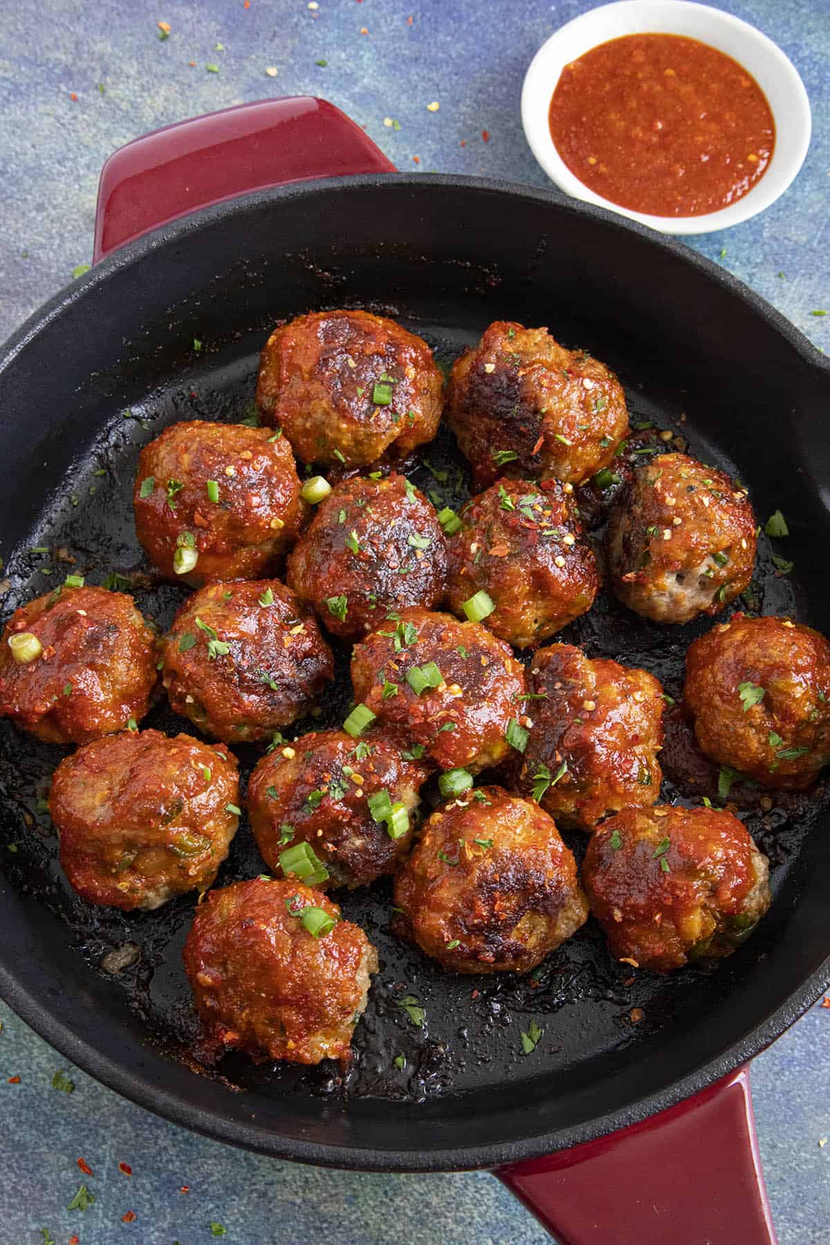 Honey Sriracha Turkey Meatballs in a pan with extra sauce