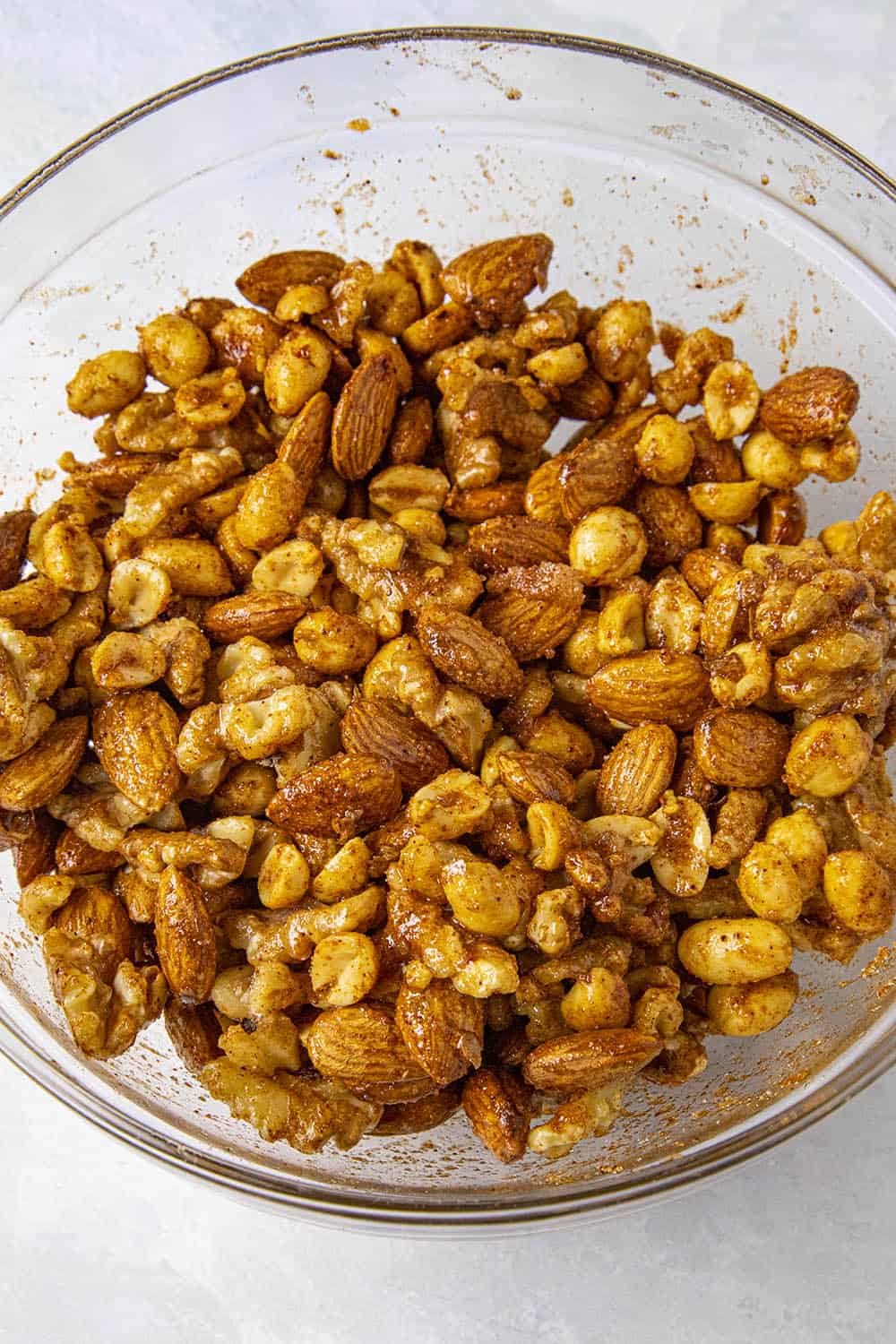 Raw nuts mixed with egg whites and seasonings, ready to bake