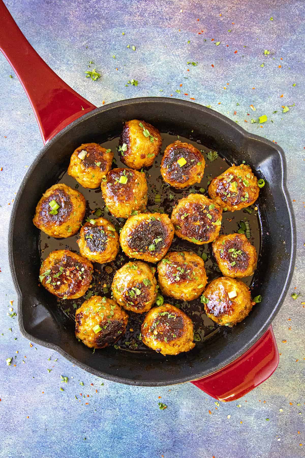 Spicy Korean Chicken Meatballs in a pan, glistening with sticky gochujang glaze