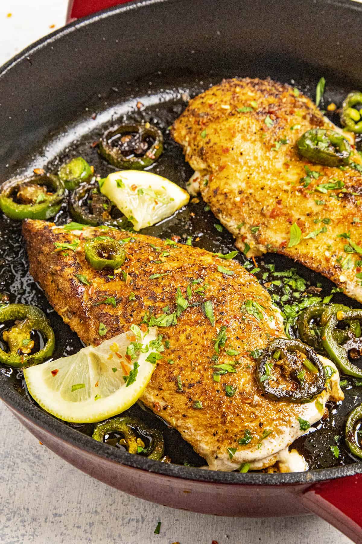 Blackened Chicken garnished with fresh herbs and chili flakes, ready to serve