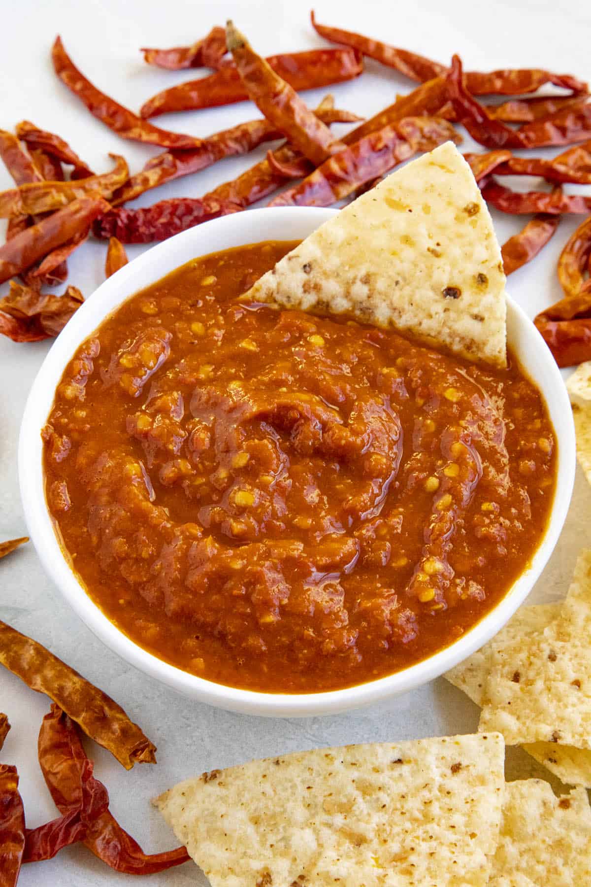 Chile de Arbol Salsa in a bowl with a chip, ready to enjoy