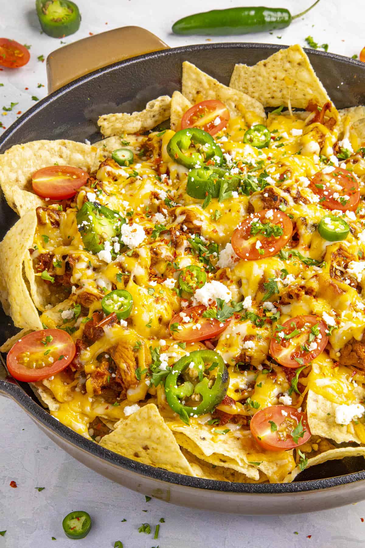 Chipotle Chicken Nachos in a pan with lots of toppings