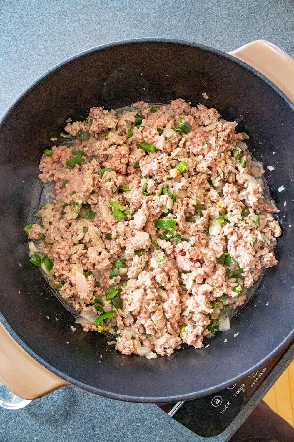 Cooking down the ground meat with peppers, onion and garlic in a pan