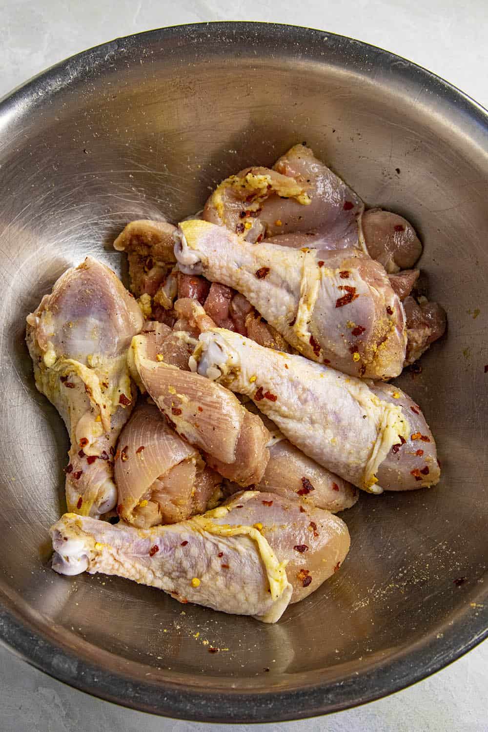 Seasoning the chicken in a bowl