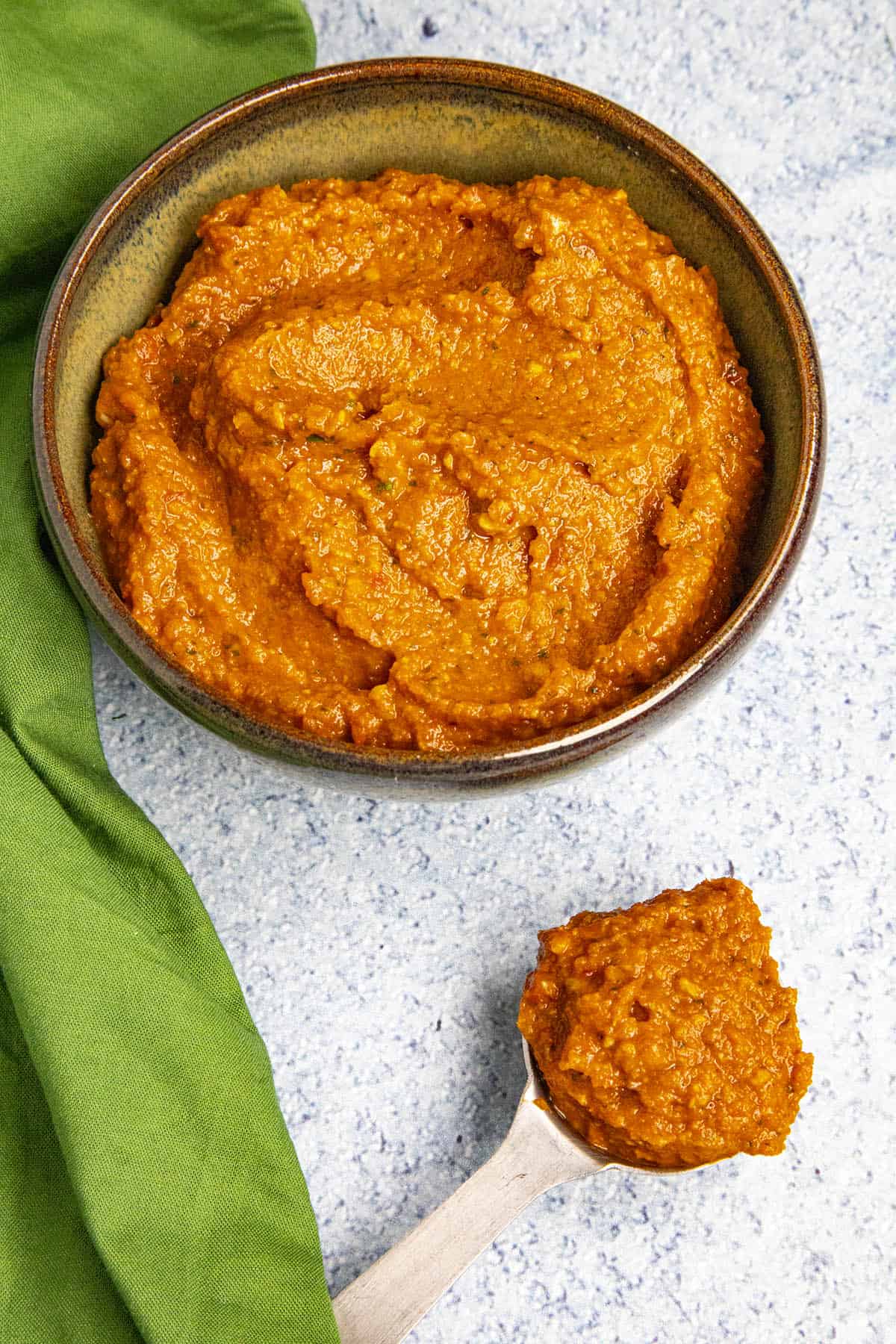 A large spoonful of Thai Red Curry Paste next to a bowl