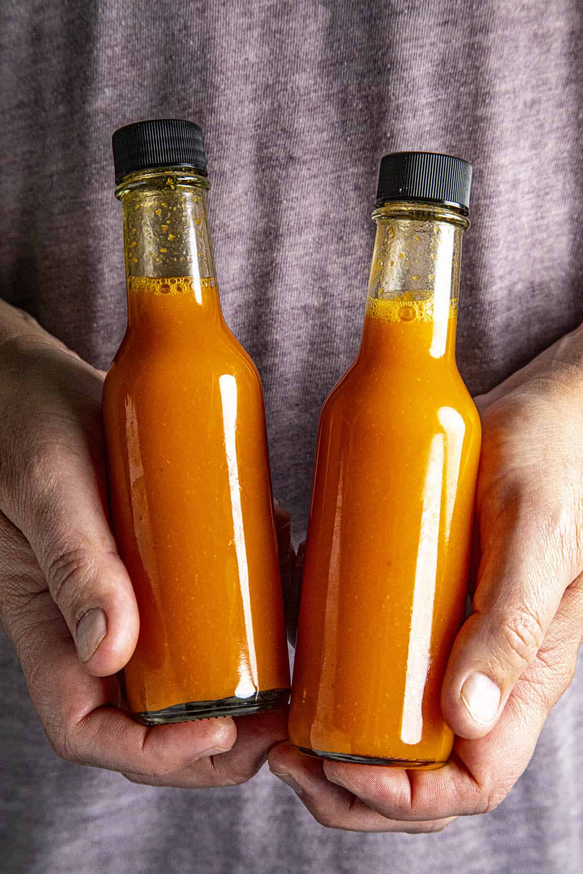 Mike holding 2 bottles of Homemade Tabasco Sauce