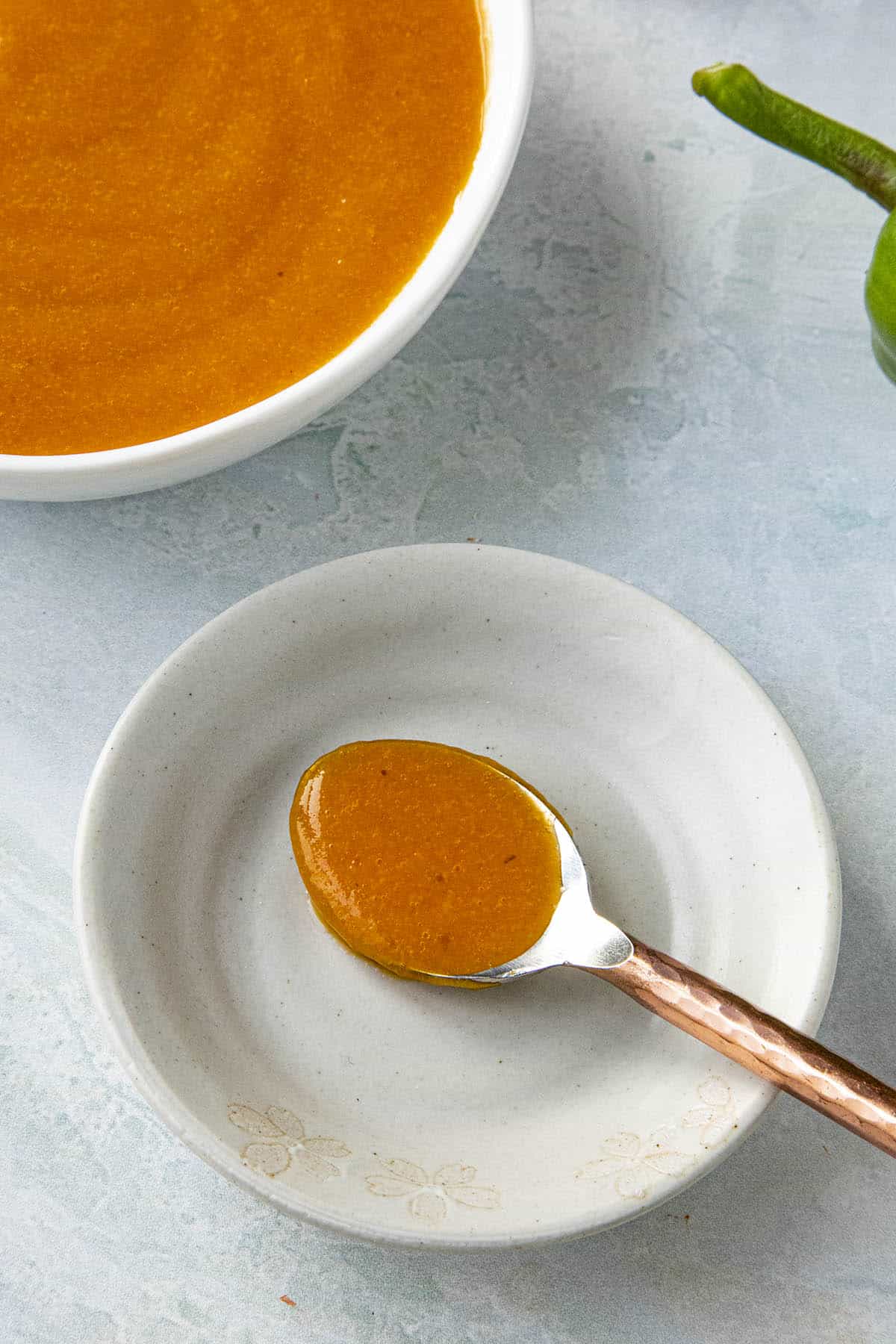 Aji Chili Sauce served in a bowl with a spoon on the side