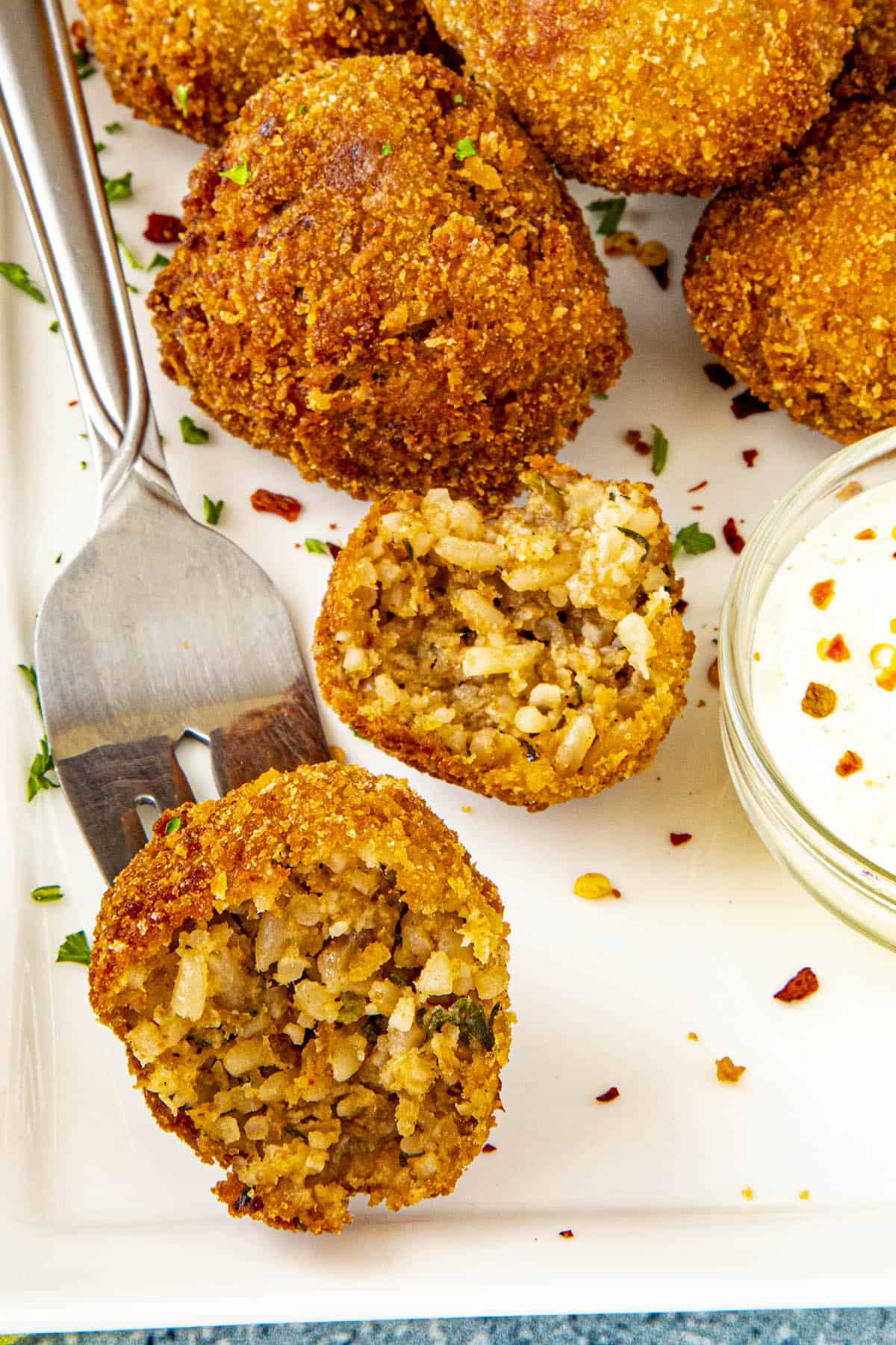 Half of a boudin ball on a fork, exposing the rice filled interior