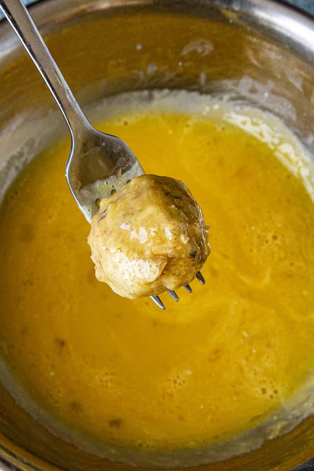 Coating the boudin balls with the egg wash mixture