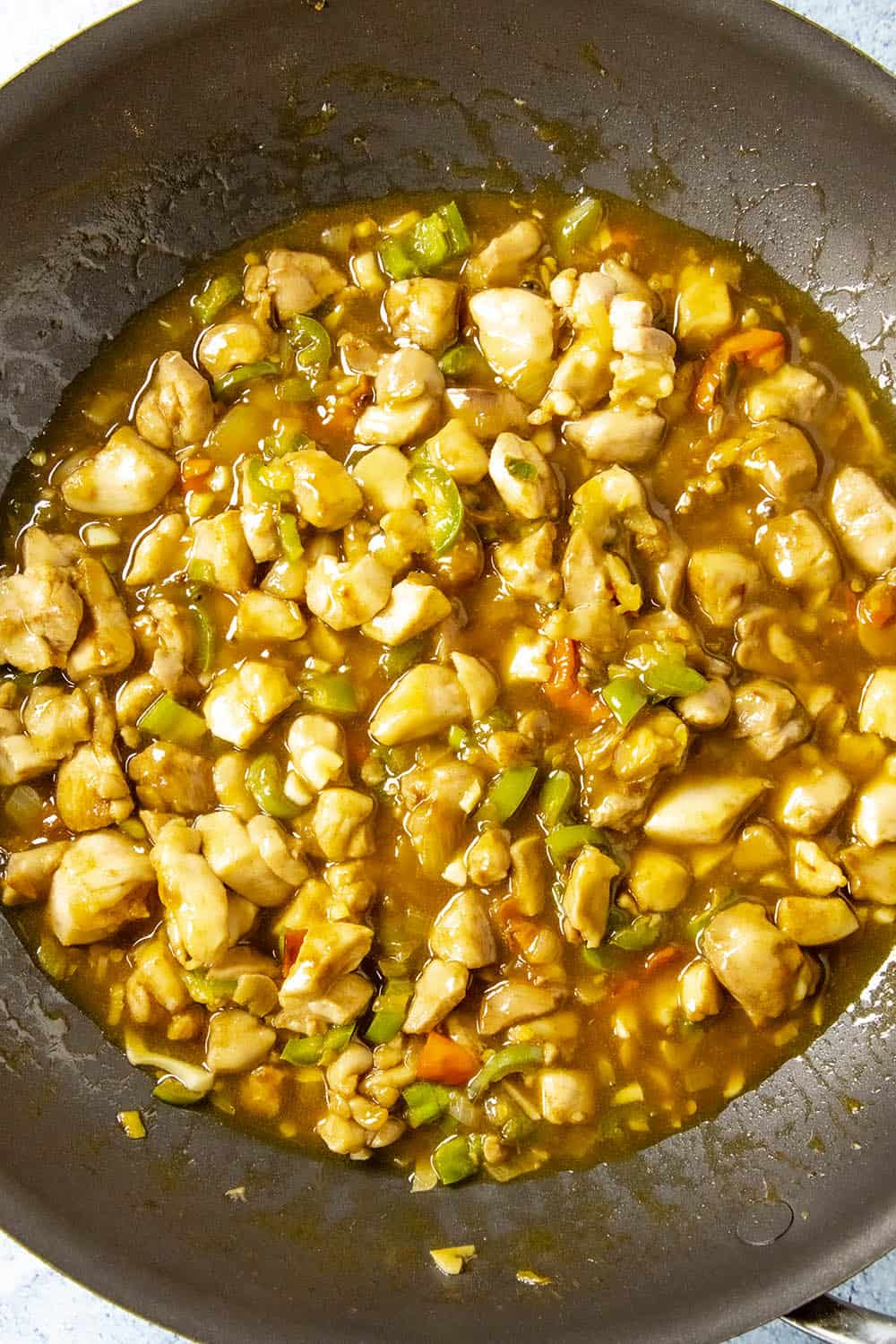 Simmering the cashew chicken in sauce