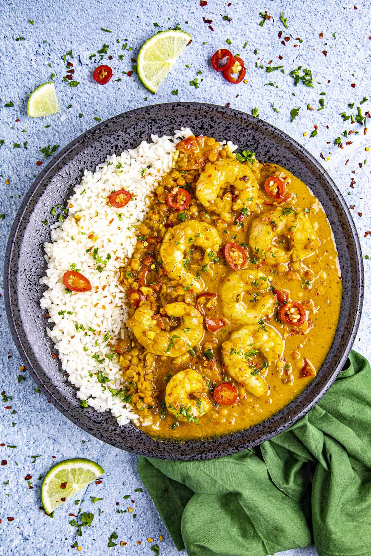 Red Curry on a plate, garnished with spicy peppers and chili flakes.