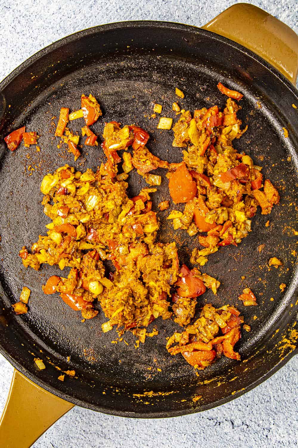 Cooking down the vegetables and red curry paste in a pan.