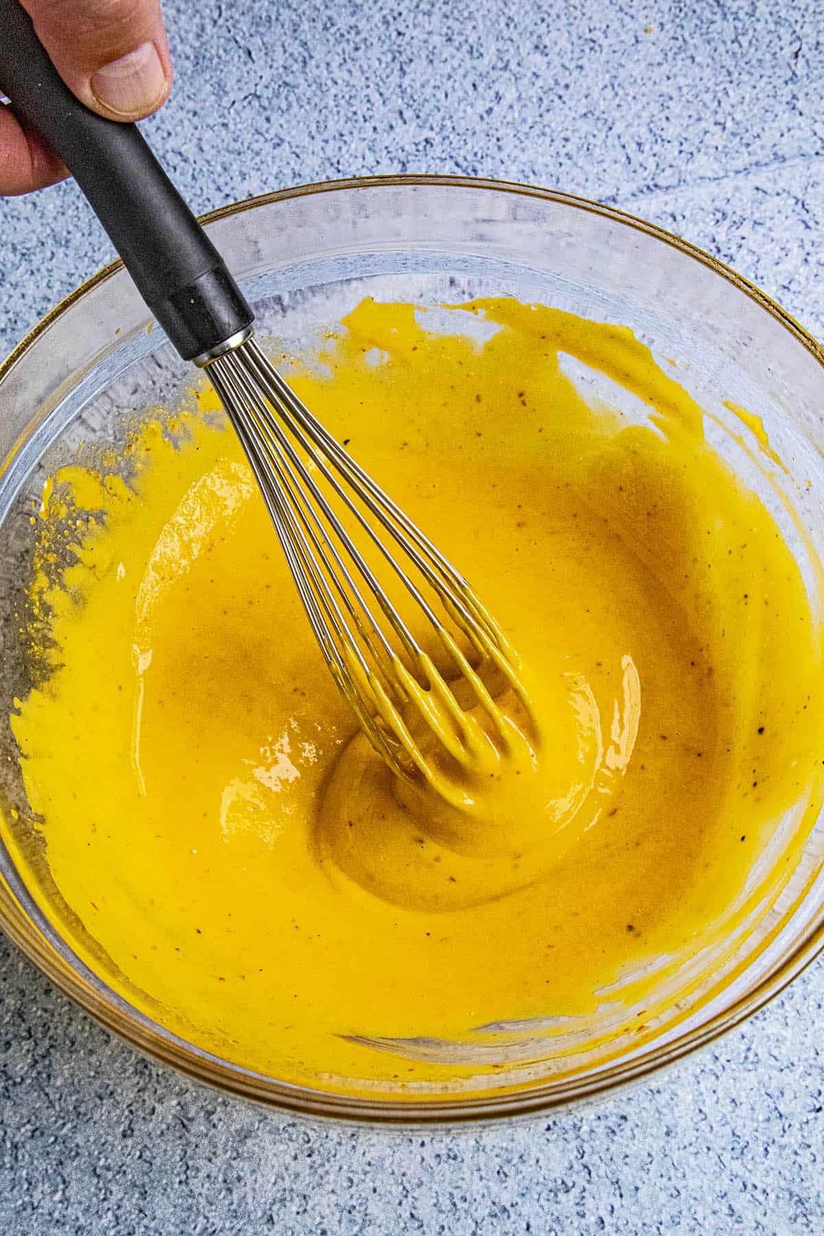 Finishing whisking sriracha aioli in a bowl