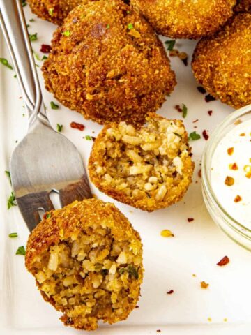 Half of a boudin ball on a fork, exposing the rice filled interior