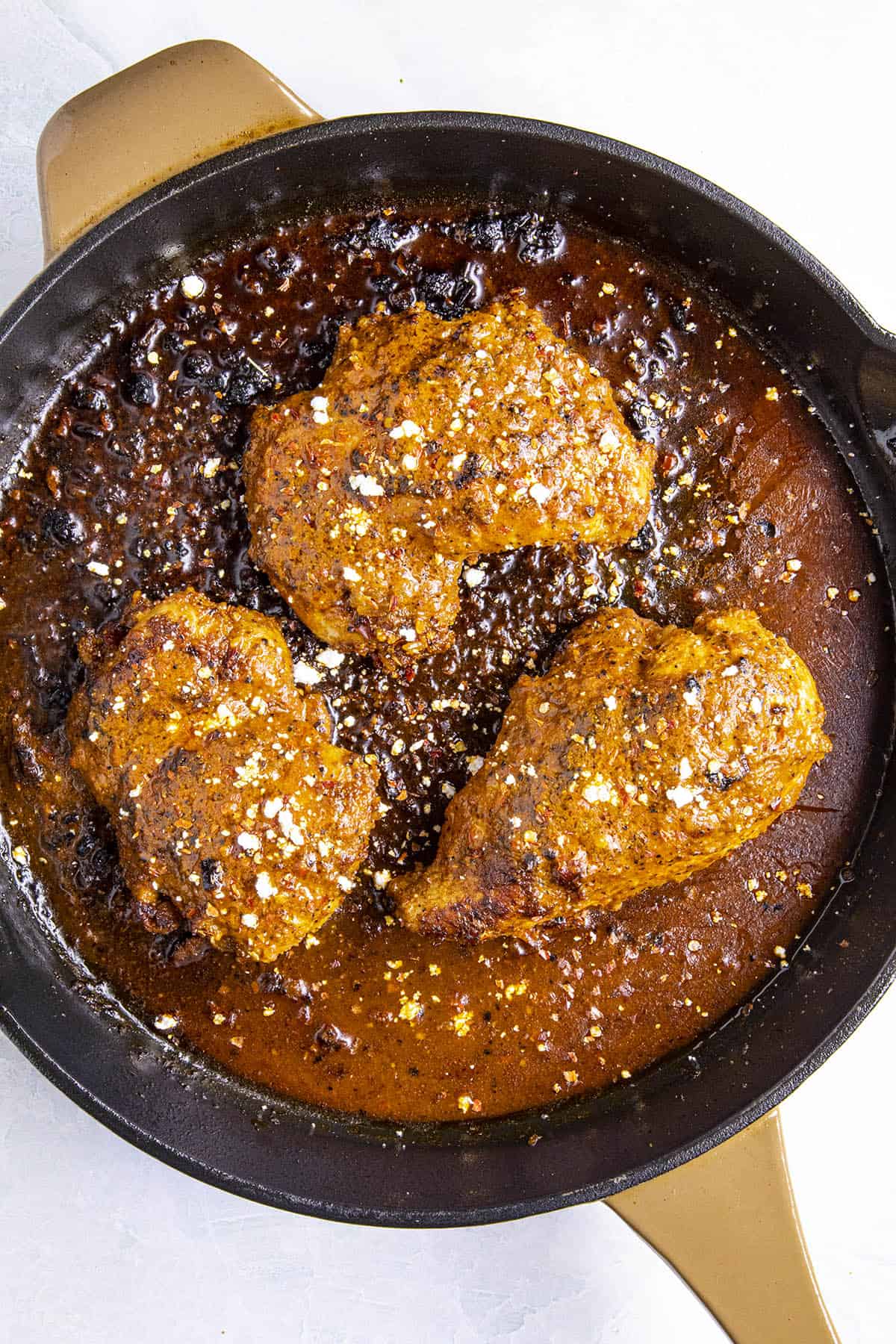 Buffalo Chicken in a pan with crumbled blue cheese for garnish