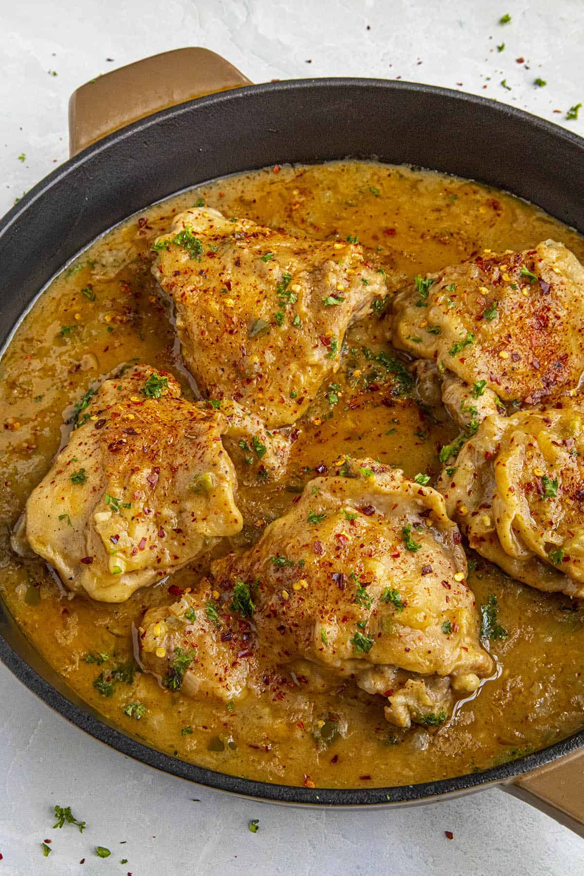 Chicken Fricassee in a pan with extra chili flakes and fresh herbs