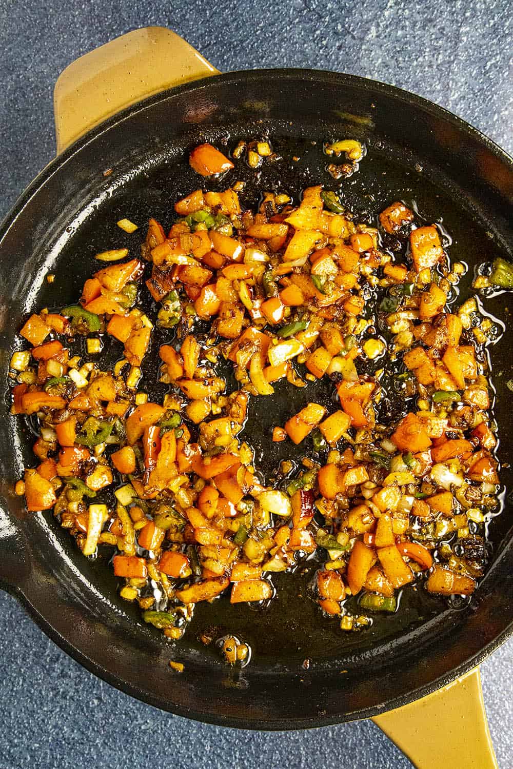 Cooking down the peppers and onions in a hot pan