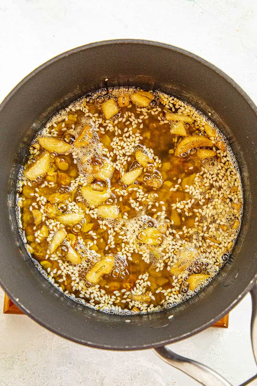 Cooking the nuts, sesame seeds and garlic cloves in the hot oil