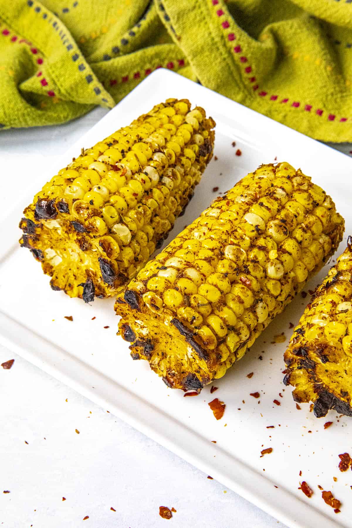 Sliced grilled corn on the cob with lots of seasonings