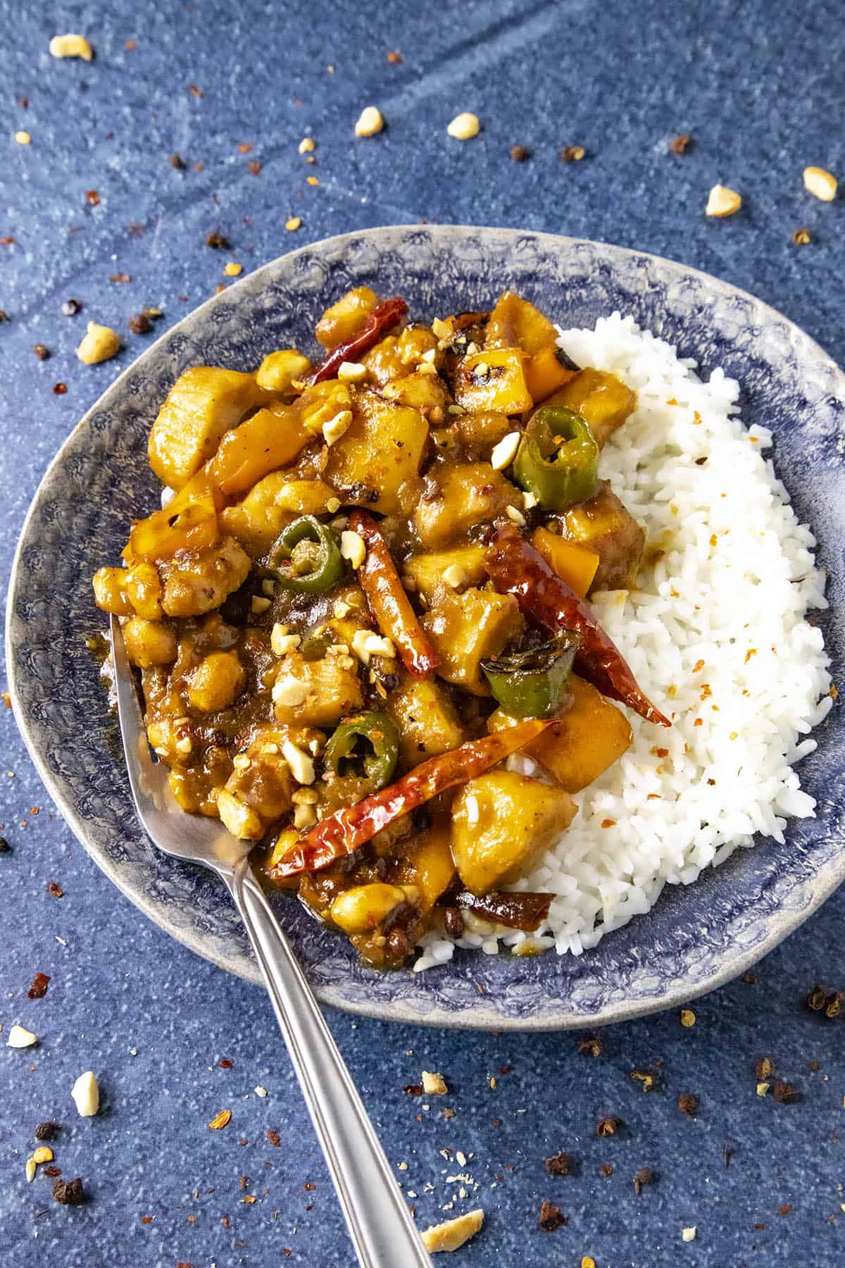 Szechuan Chicken on a plate with a fork, ready to serve