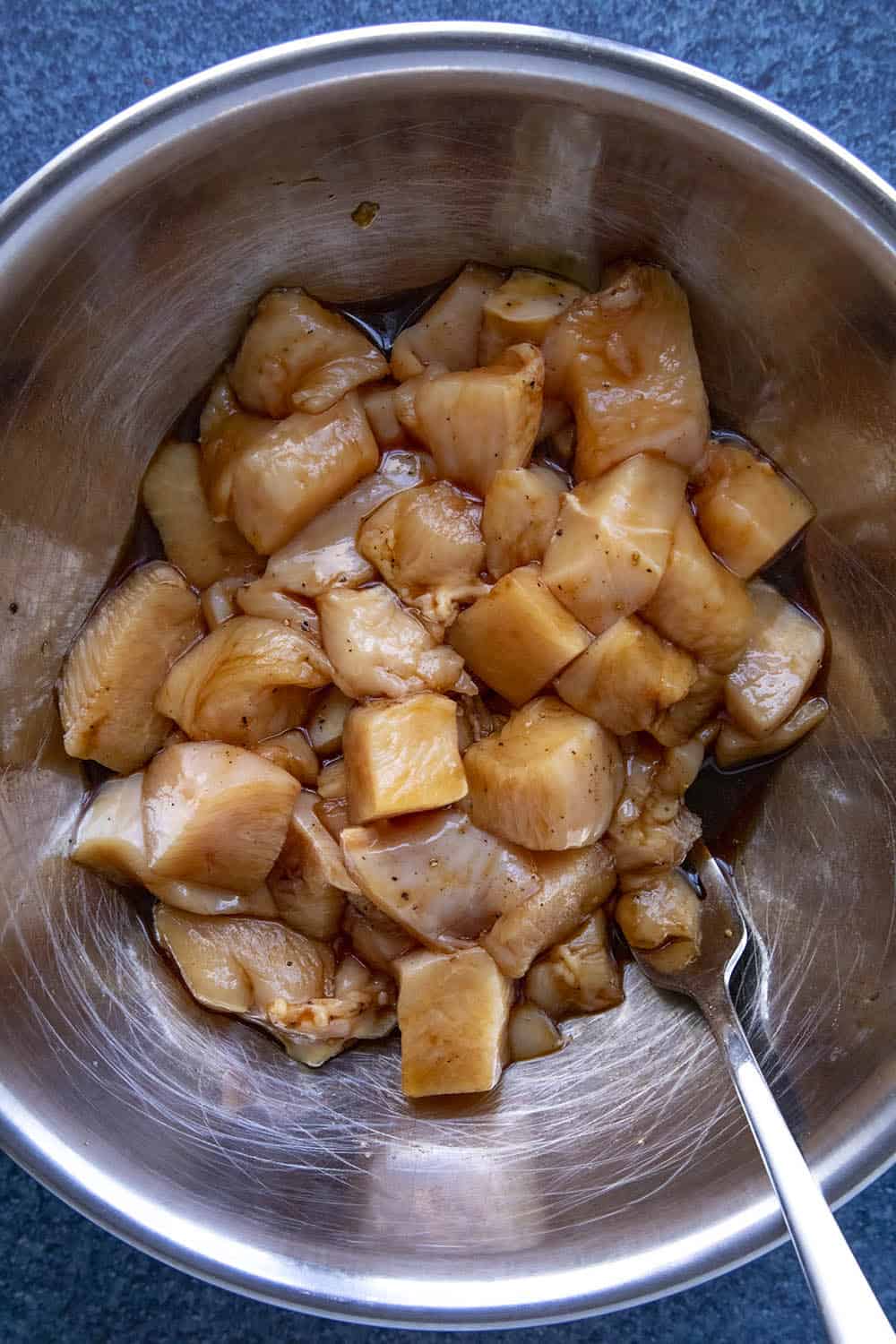 Seasoning the chopped chicken in a bowl