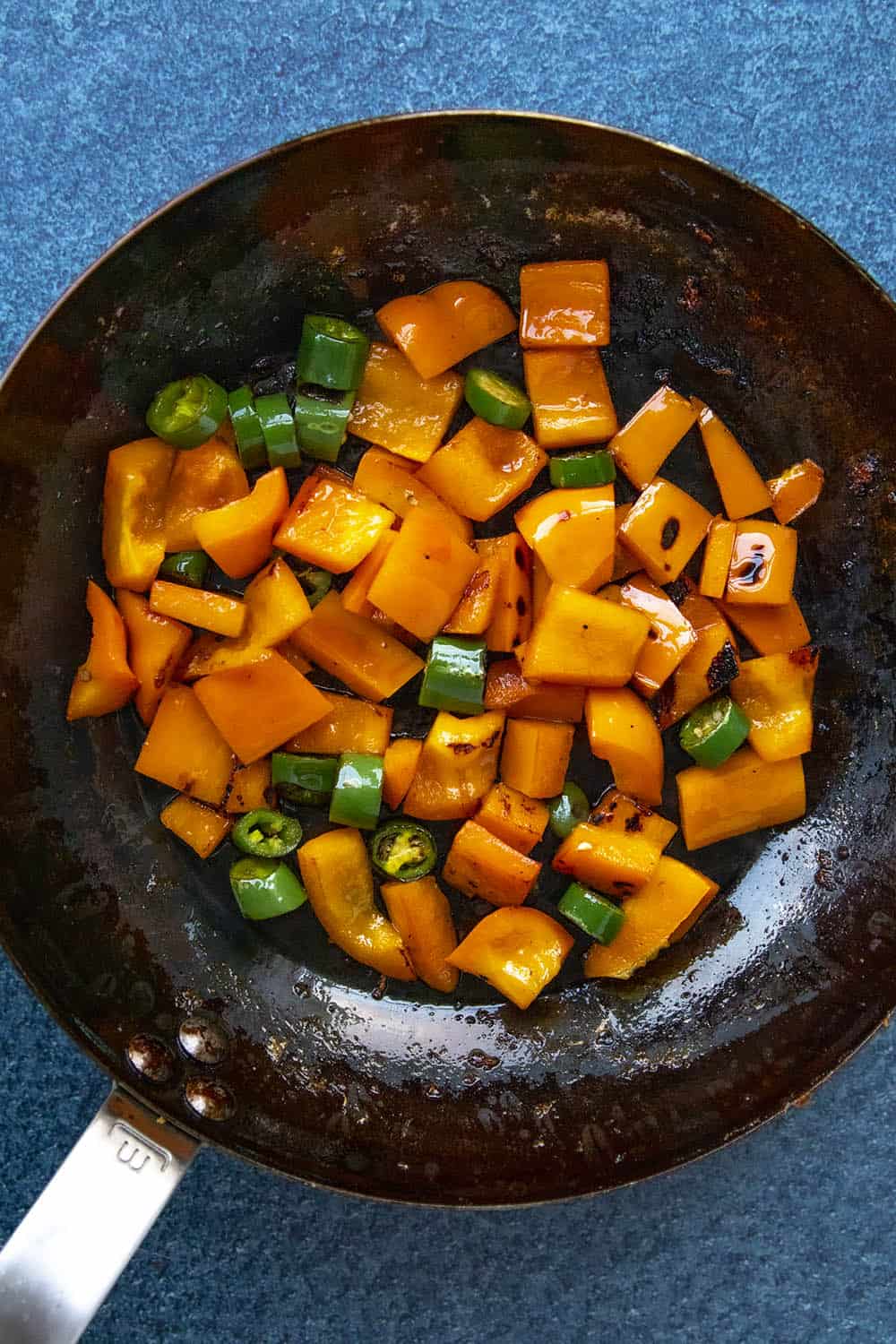 Cooking the chopped peppers in a hot pan