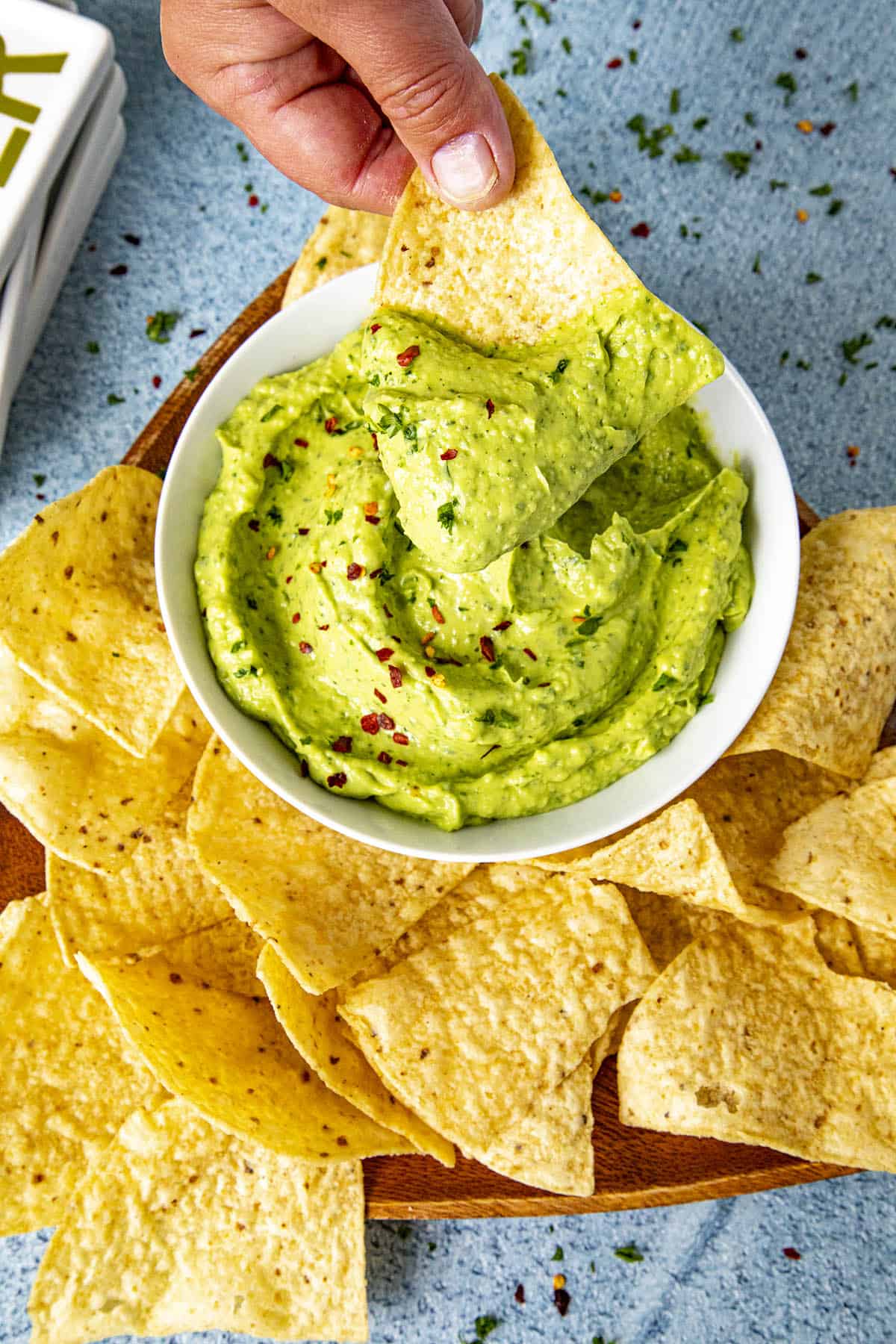 Mike taking a big scoop of creamy guasacaca on a tortilla chip