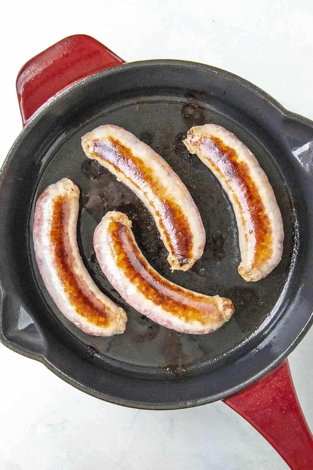 Browning sausages in a hot pan.