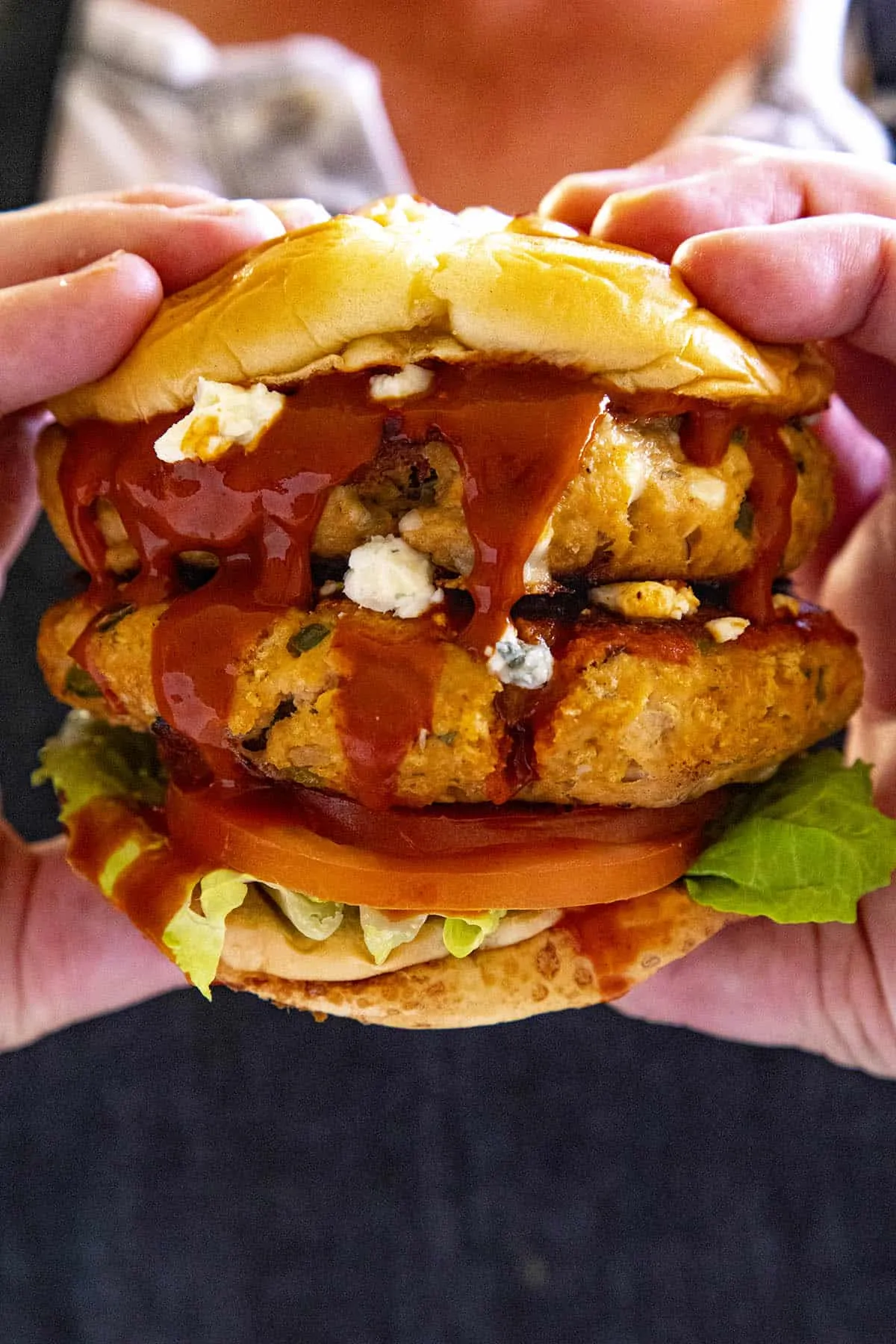 Mike holding a double Buffalo chicken burger with extra Buffalo sauce