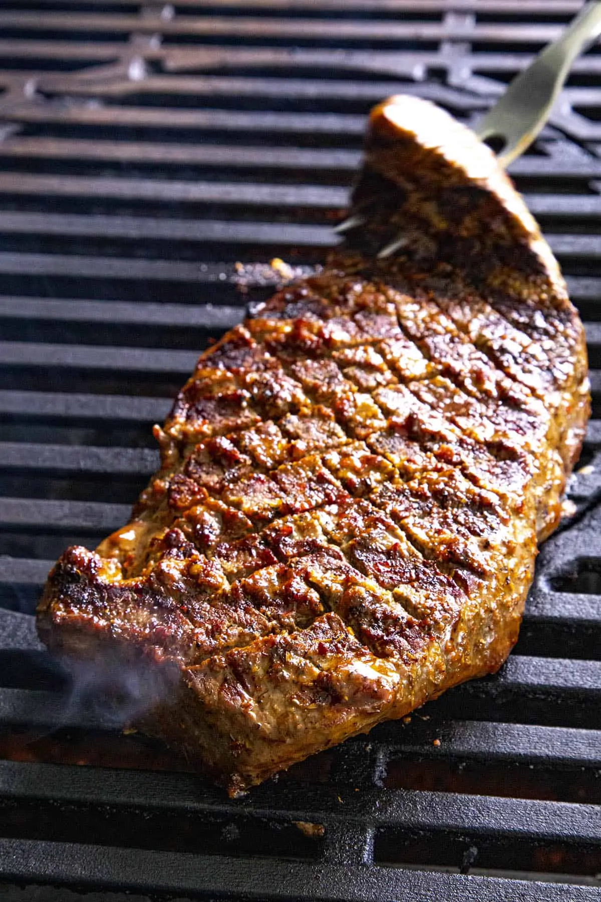 Flipping a London broil steak on the grill
