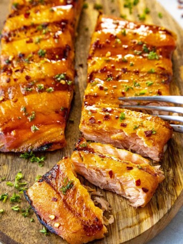 Cutting into flaky grilled salmon with a fork