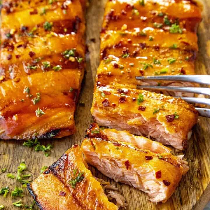 Cutting into flaky grilled salmon with a fork