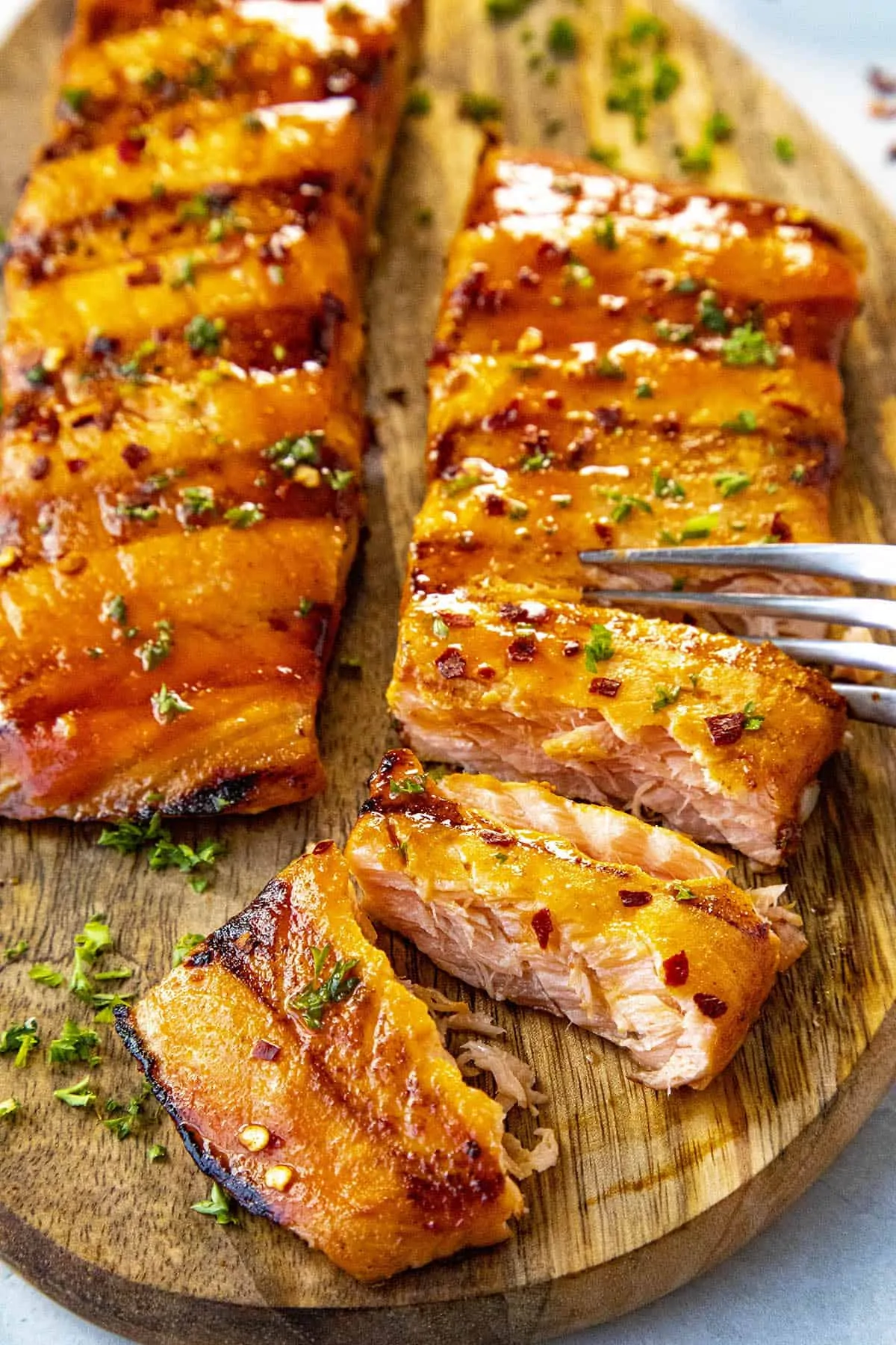 Cutting into flaky grilled salmon with a fork