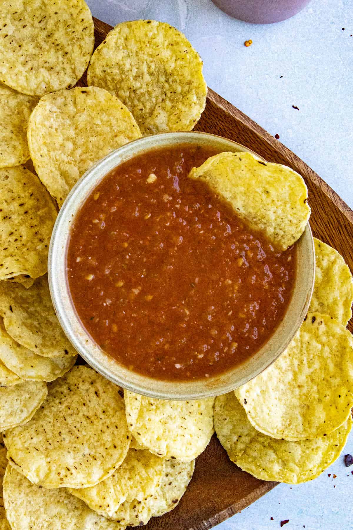 A corn chip dipped into salsa roja