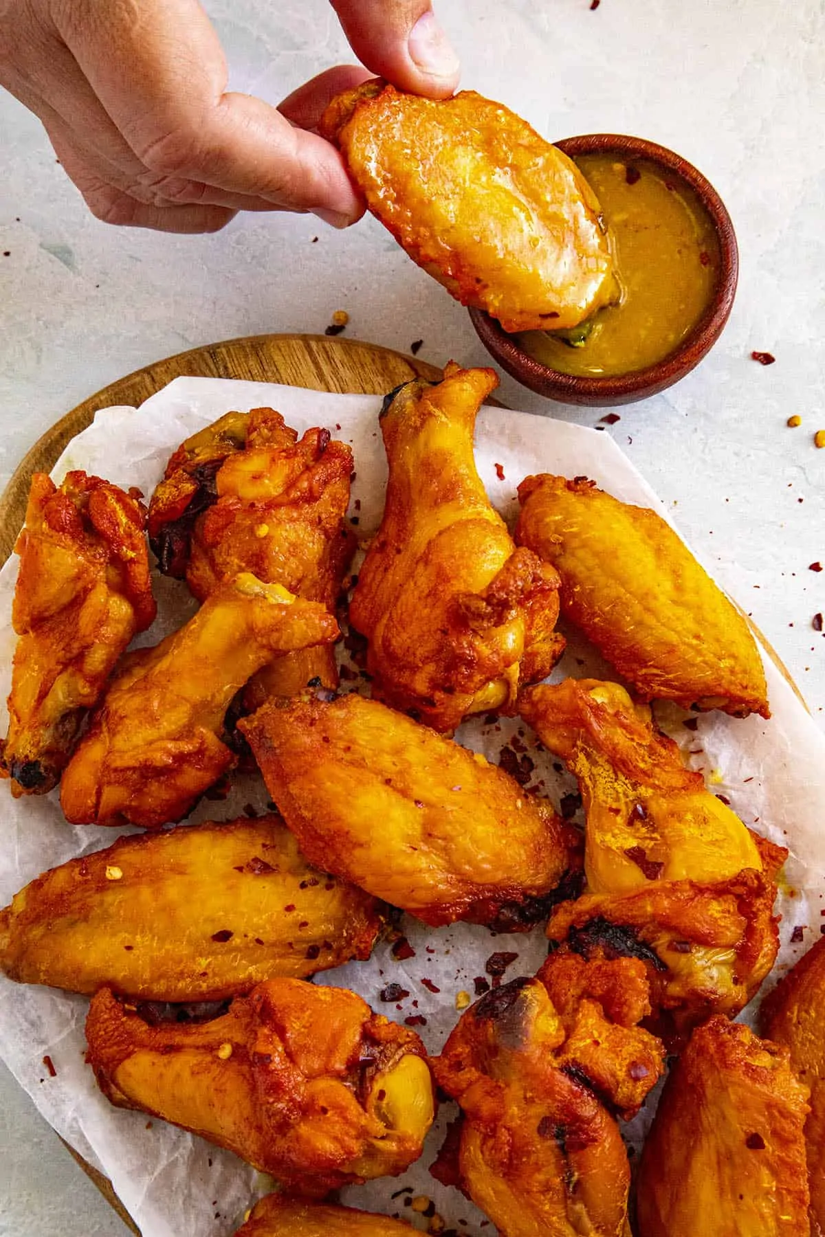 Dipping a smoked chicken wing into wing sauce