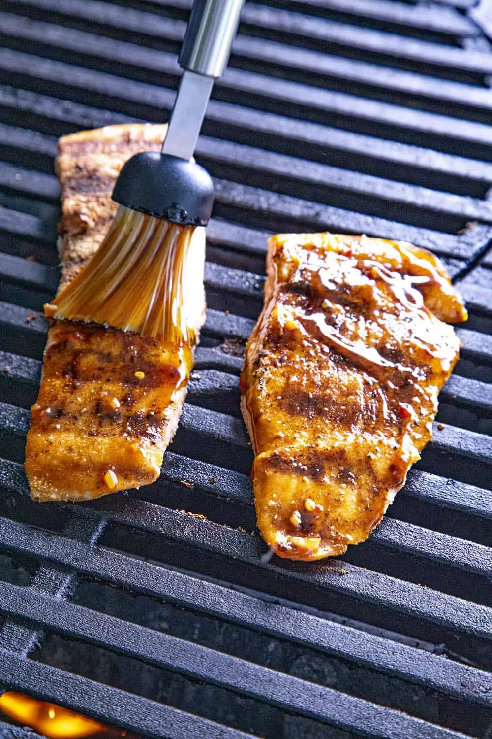 Brushing teriyaki sauce onto salmon on the grill