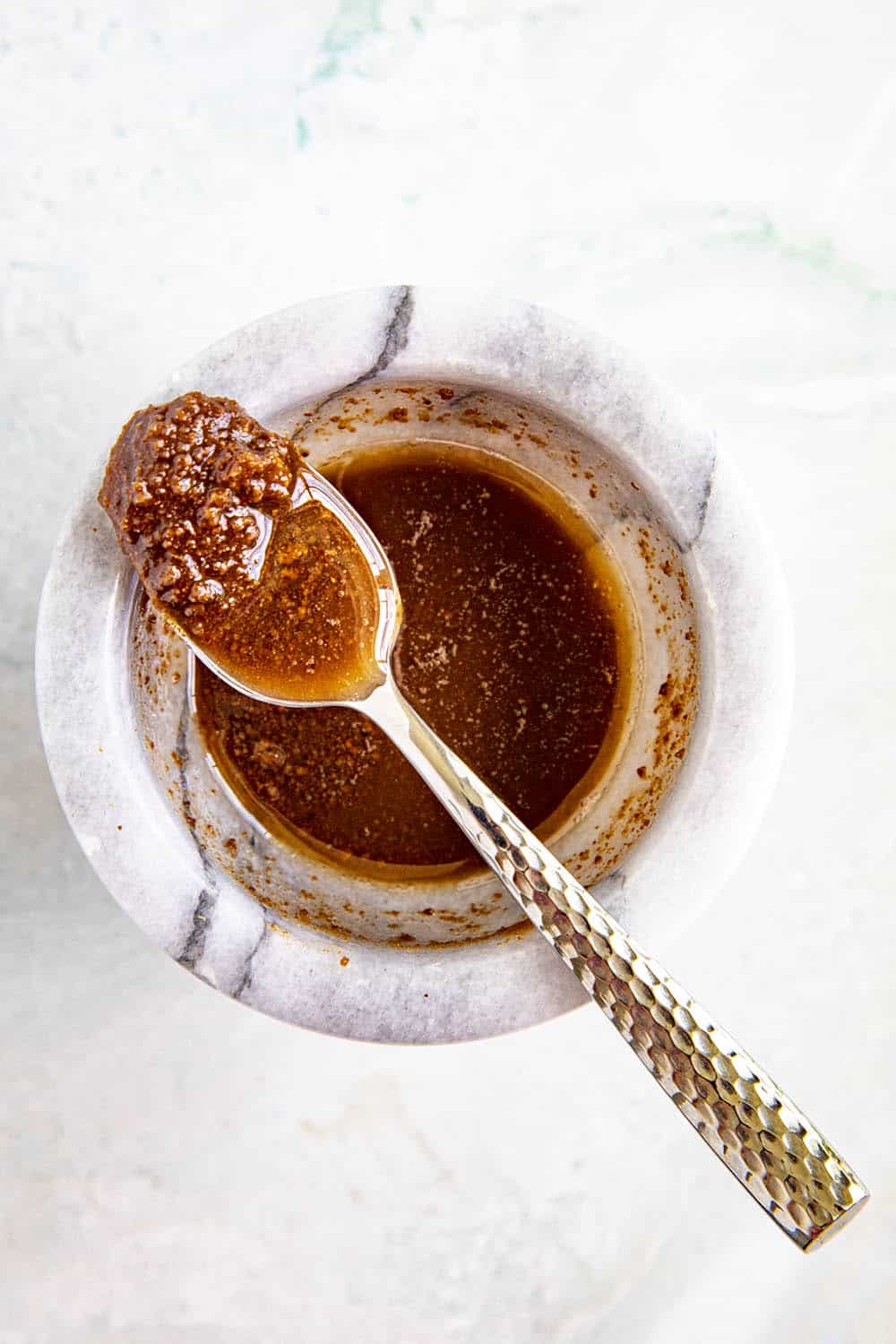 Flavorful shrimp paste on a spoon for making Sambal Matah