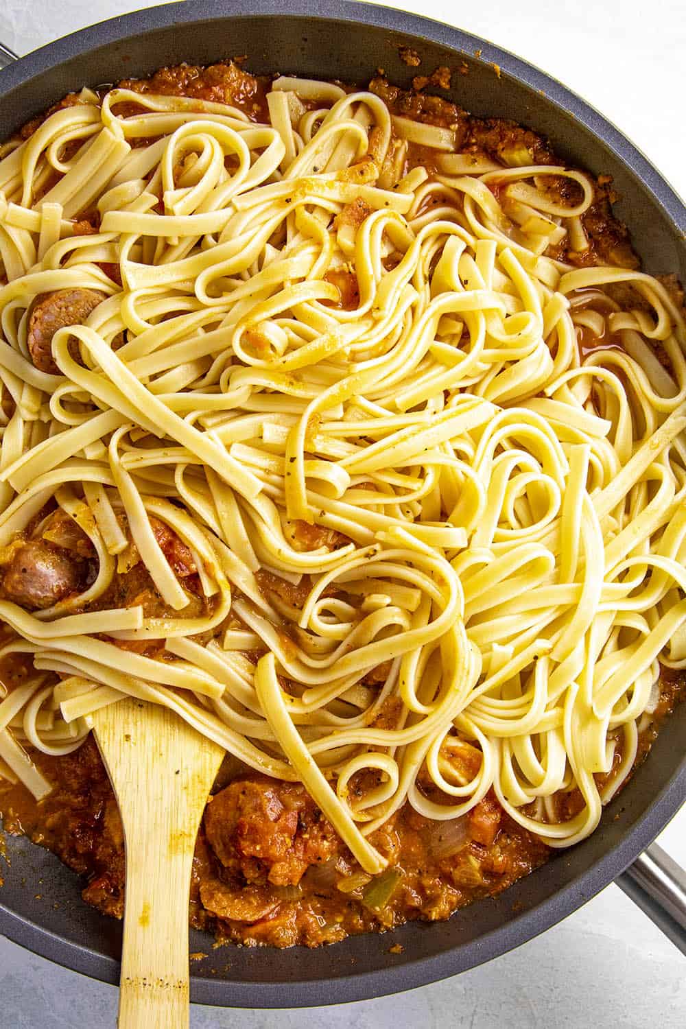 Swirling pasta noodles into our Cajun pasta sauce.