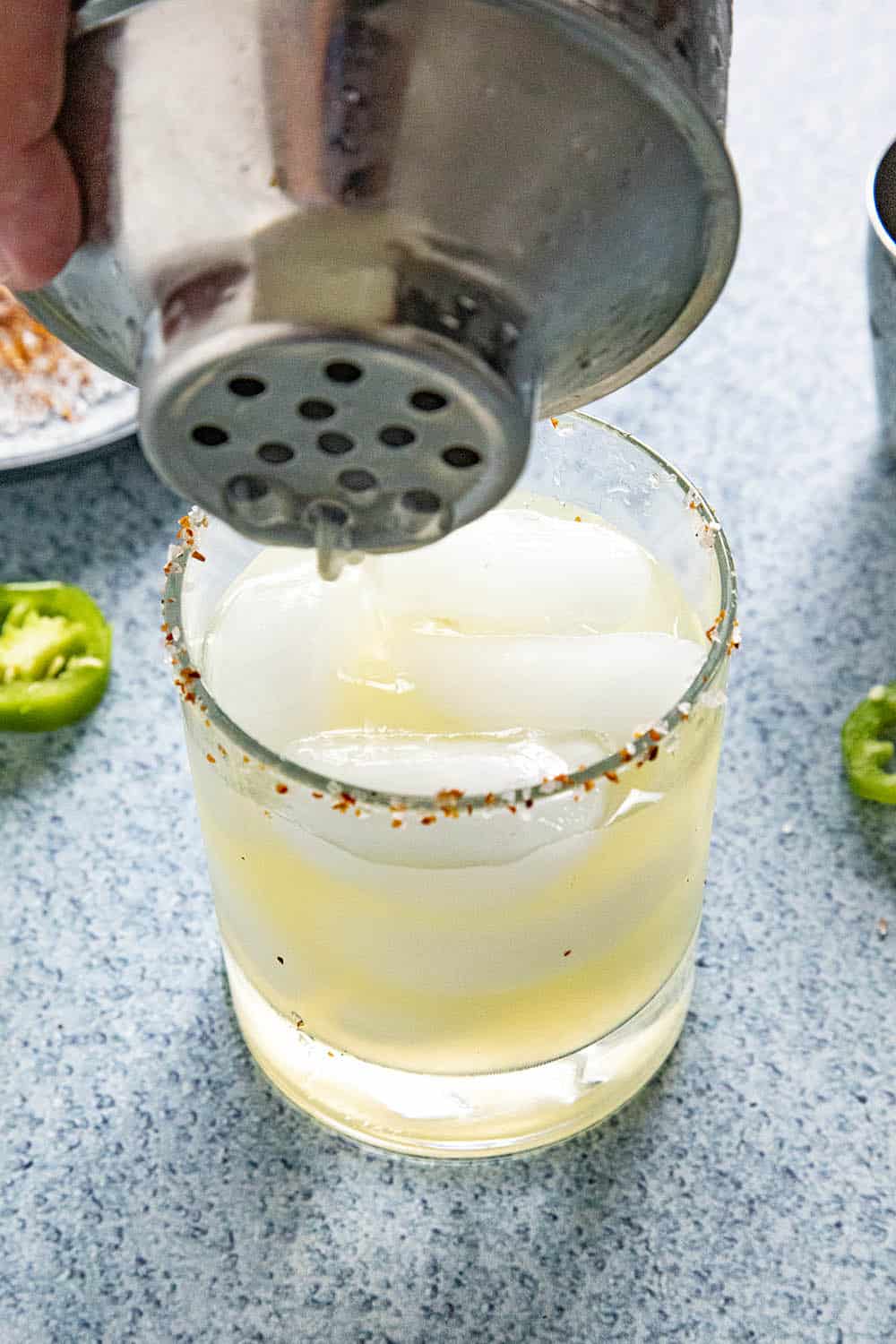 Pouring a Jalapeno Margarita from a shaker into a glass